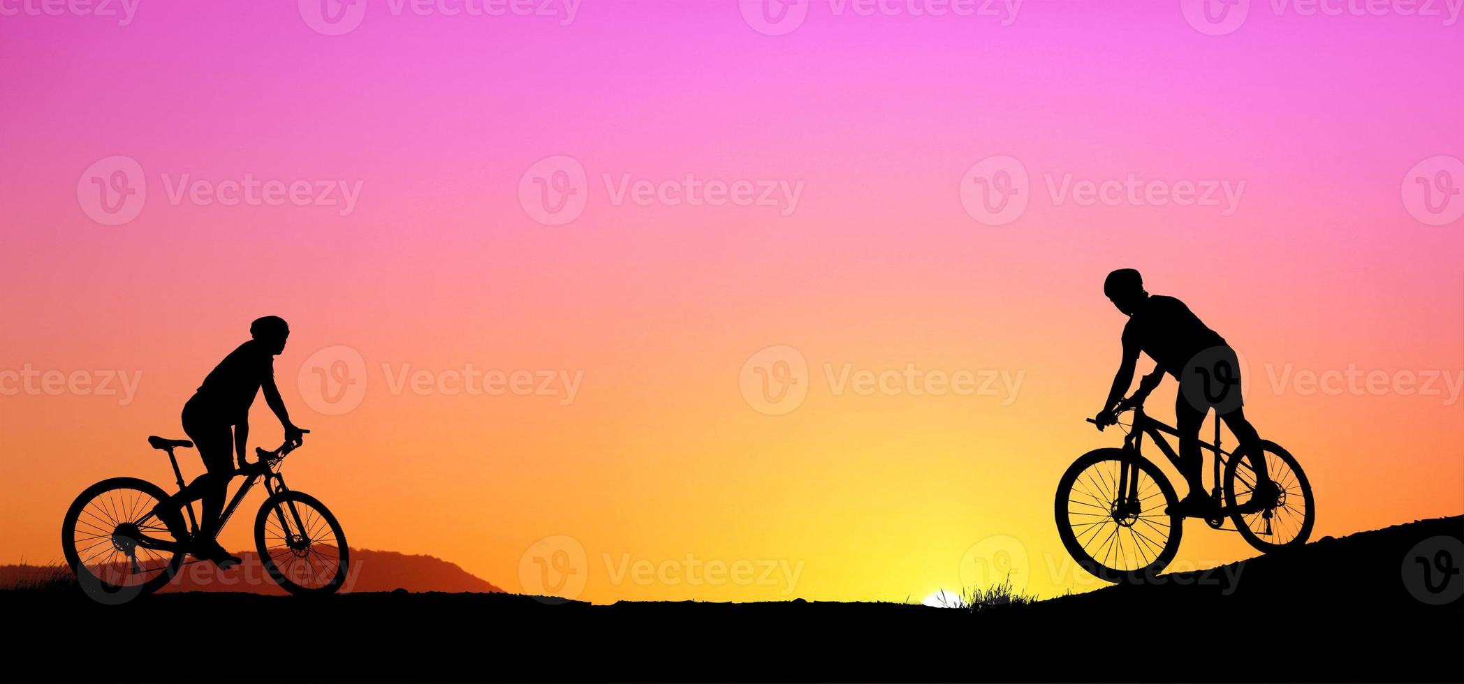 Silhouette of a mountain biker enjoying downhill during the sunset. Mountain bike concept. Mountain bike race - silhouette cyclist on background. photo