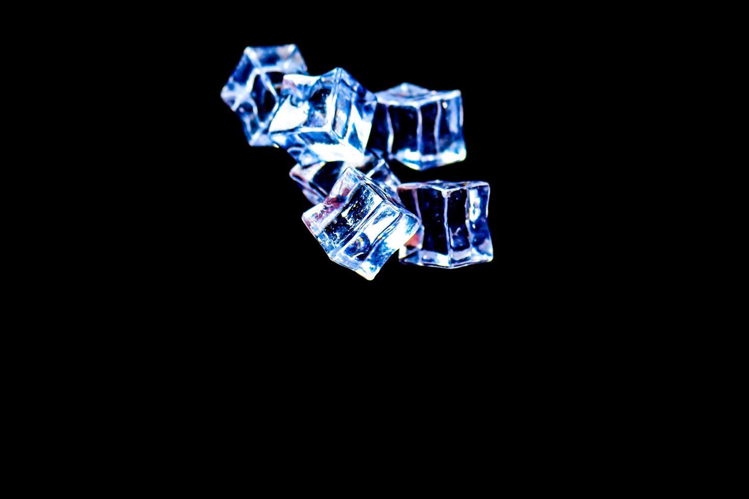 Ice cubes on a black background. ice falling on a black background for use as an illustration in a project photo