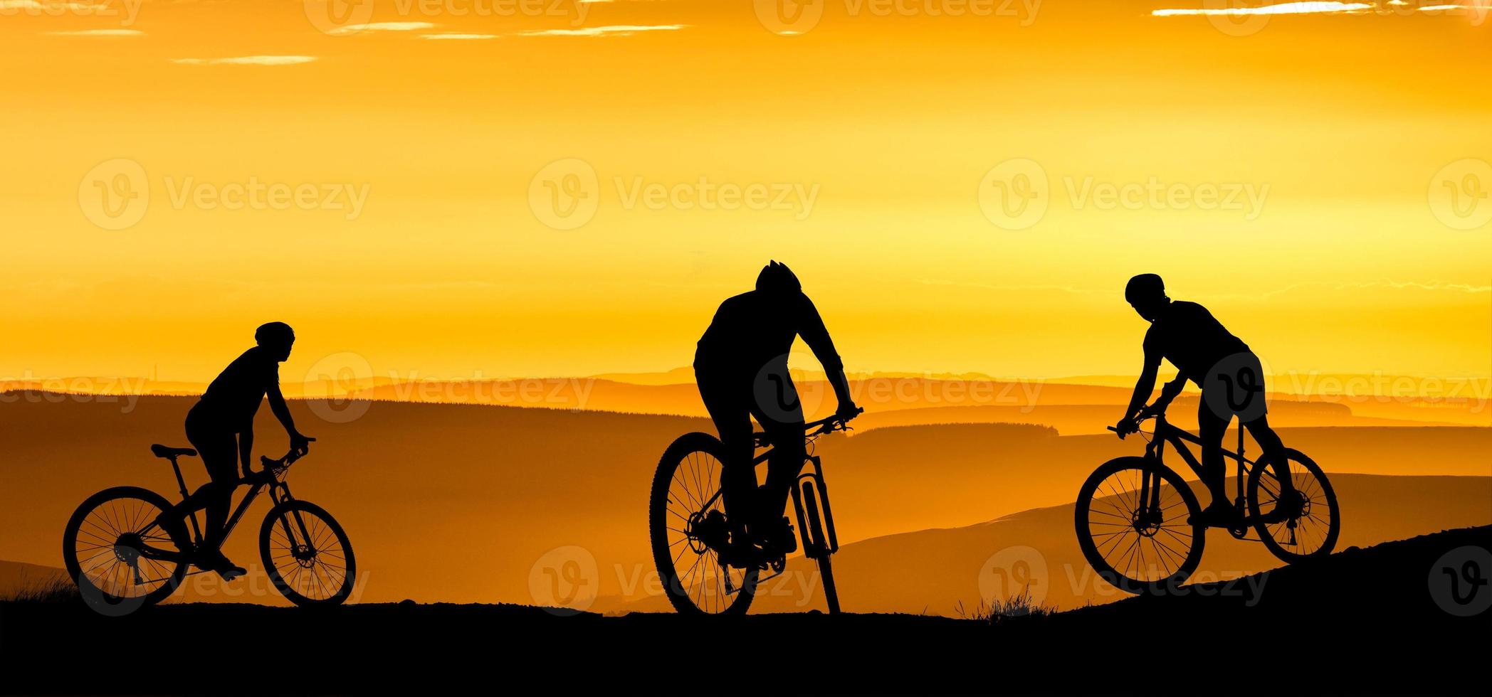 silueta de un ciclista de montaña disfrutando cuesta abajo durante la puesta de sol. concepto de bicicleta de montaña. carrera de bicicleta de montaña - ciclista de silueta en el fondo. foto
