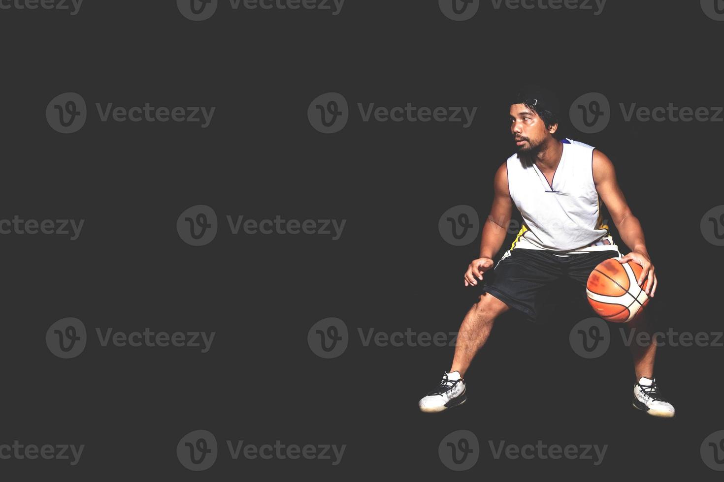 Gesture of Asian basketball player dribbling on black background. Basketball concept in Asia photo