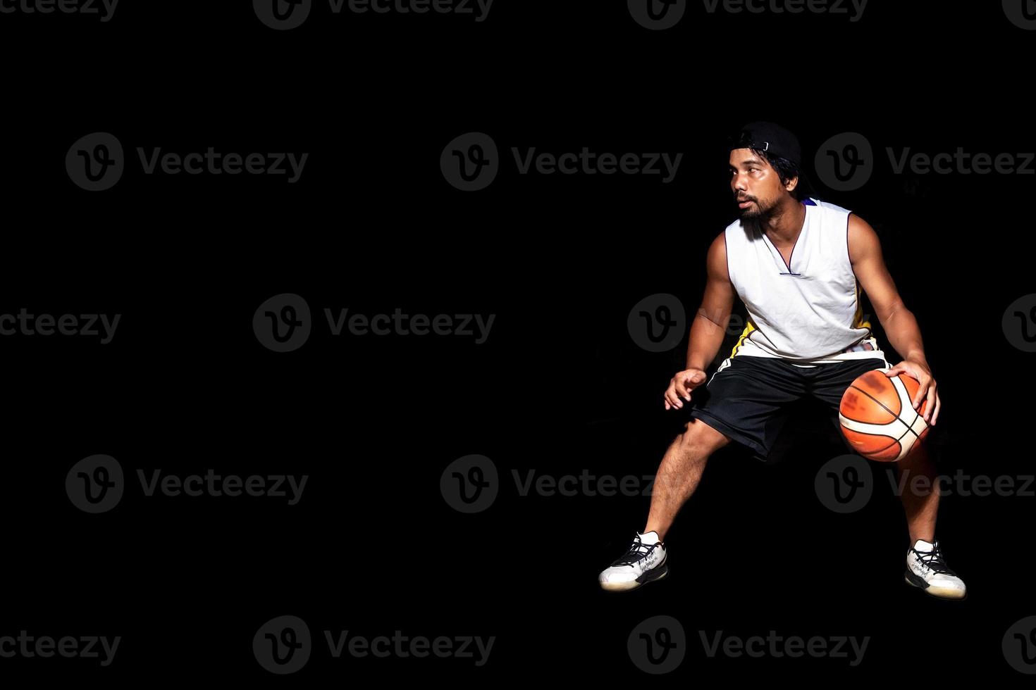 Gesture of Asian basketball player dribbling on black background. Basketball concept in Asia photo