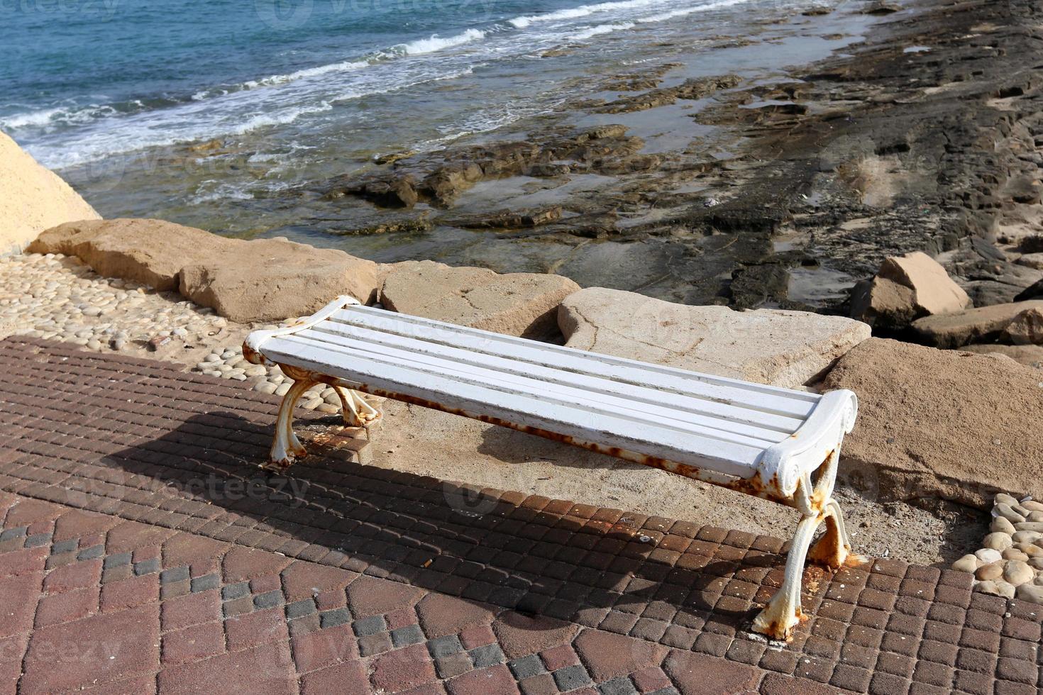 Bench for rest in a city park on the shores of the Mediterranean Sea. photo