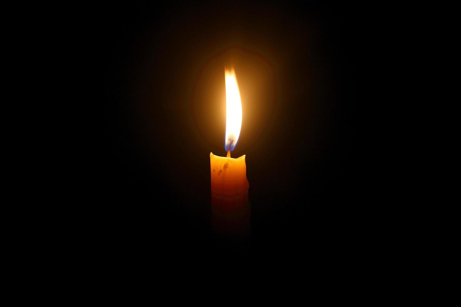 Light for life - Yellow candle light against black background photo