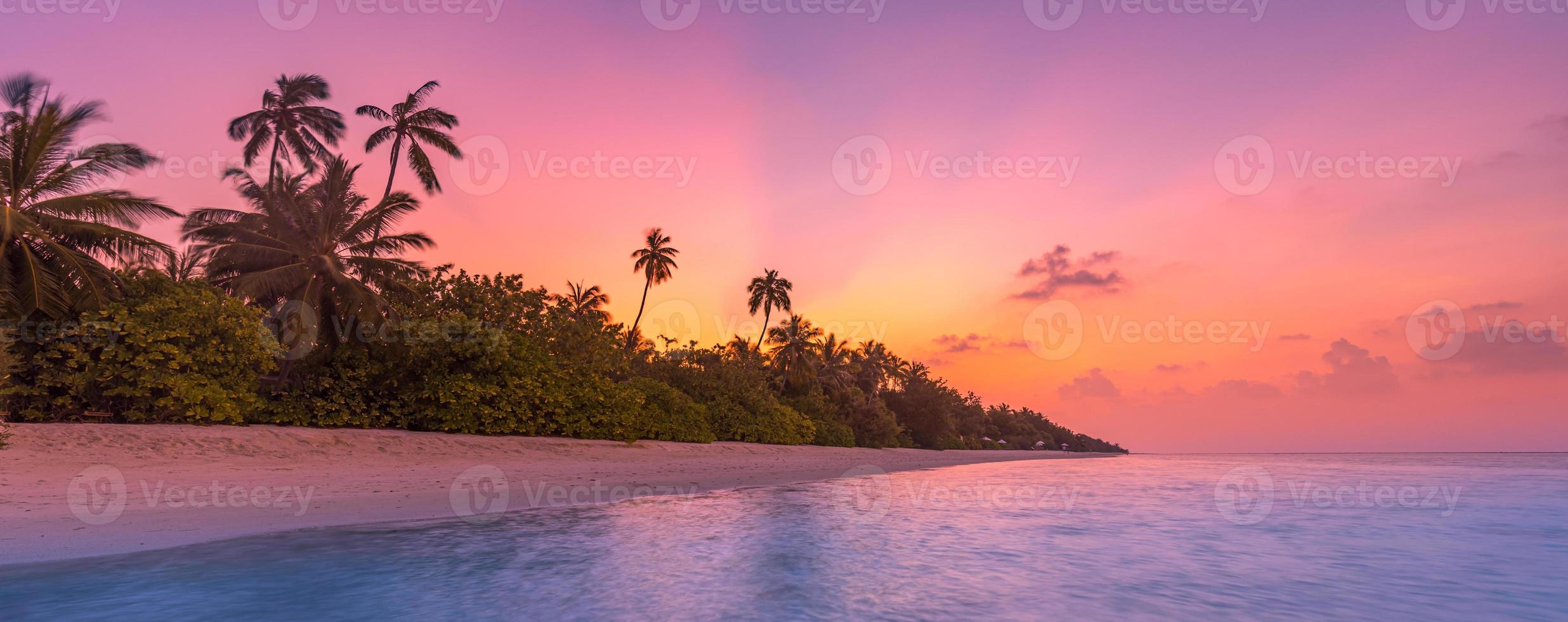 Palm trees on the tropical beach, amazing sunset, tropical island coast. Sun rays, dream romantic exotic beach landscape. Palm trees, calm lagoon sea horizon. photo