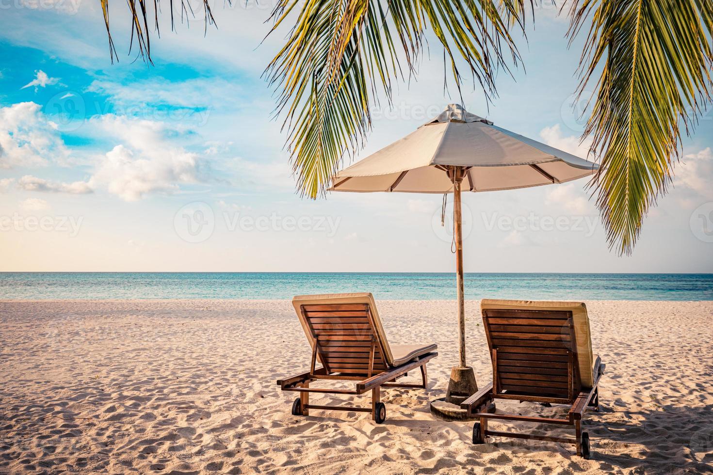 hermosa playa. sillas en la playa de arena cerca del mar. concepto de vacaciones y vacaciones de verano para el turismo. paisaje tropical inspirador. paisaje tranquilo, playa relajante, diseño de paisaje tropical foto