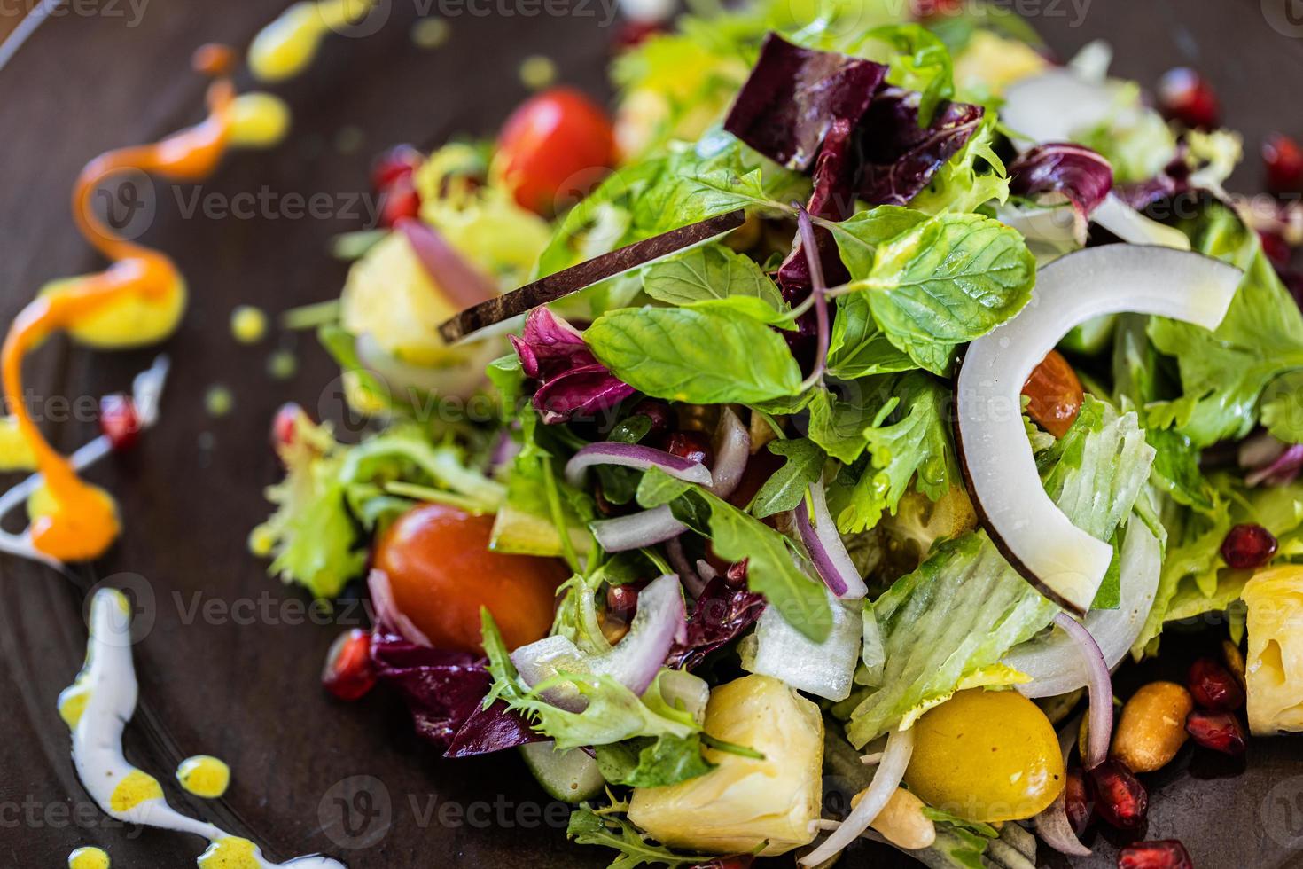 ensalada verde con rodajas de aguacate, tomates cherry, aceitunas negras y queso. ensalada vegetariana de verduras de verano de dieta saludable. ajuste de la tabla. concepto de comida vista superior. foto