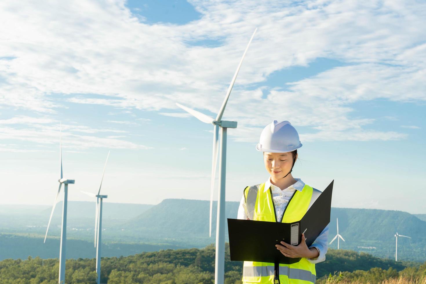 mujeres ingenieras trabajando y sosteniendo el informe en la estación generadora de energía de la granja de turbinas eólicas en la montaña, gente de tailandia foto