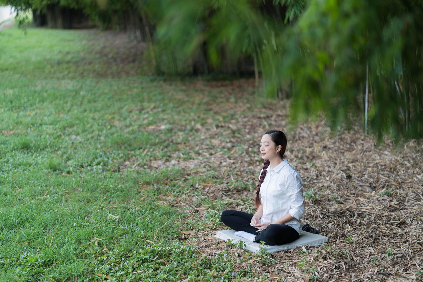 Beautiful young woman meditating in nature photo