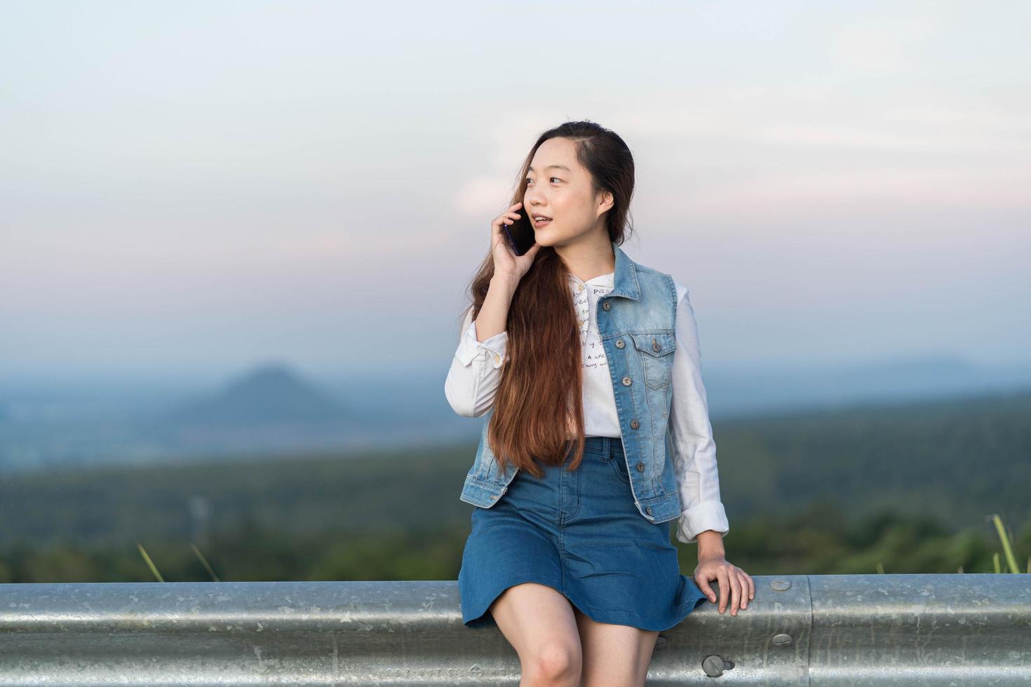 Portrait of woman talking with friend on mobile phone and smiling. photo