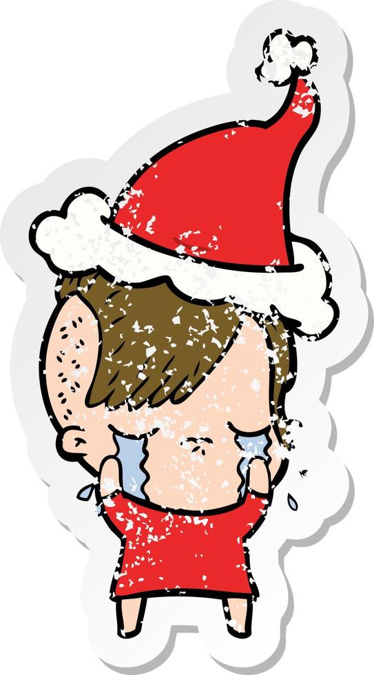 distressed sticker cartoon of a crying girl wearing santa hat vector