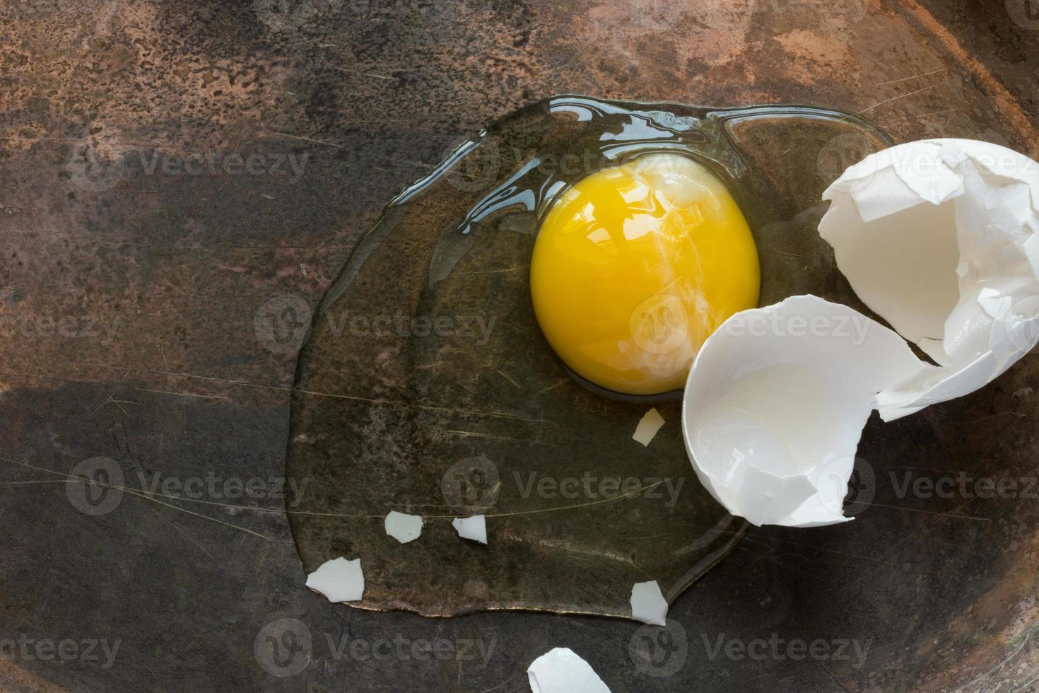 cracked white egg with whole yolk top view photo