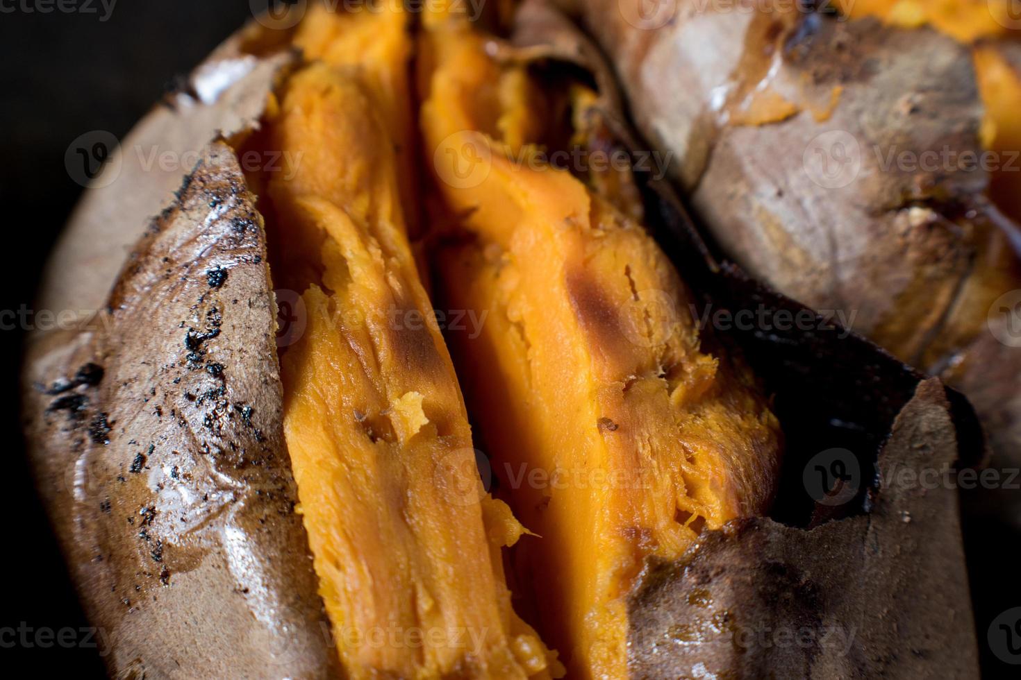 baked sweet potatoes sliced open with butter in fall setting photo