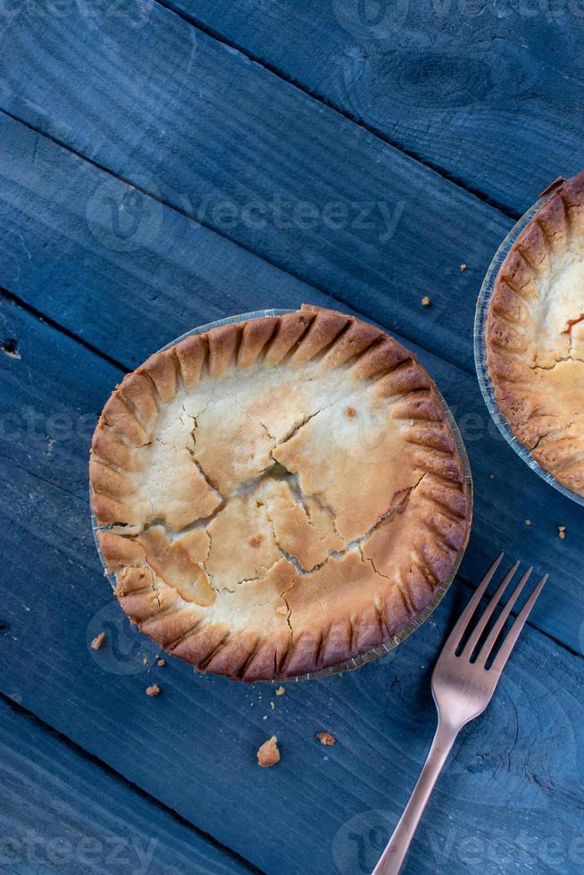 baked golden brown mini chicken pot pies on rustic background flat lay photo