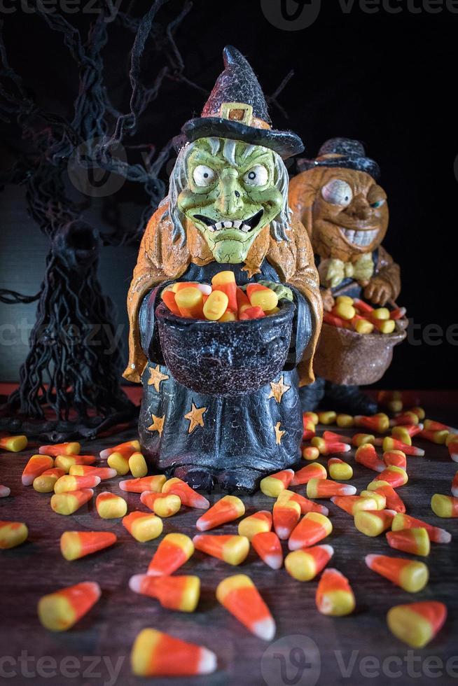 Halloween characters in spooky background collecting candy corn photo