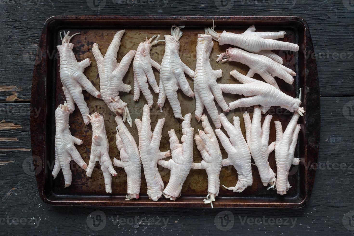 raw chicken feet on metal baking sheet flat lay photo