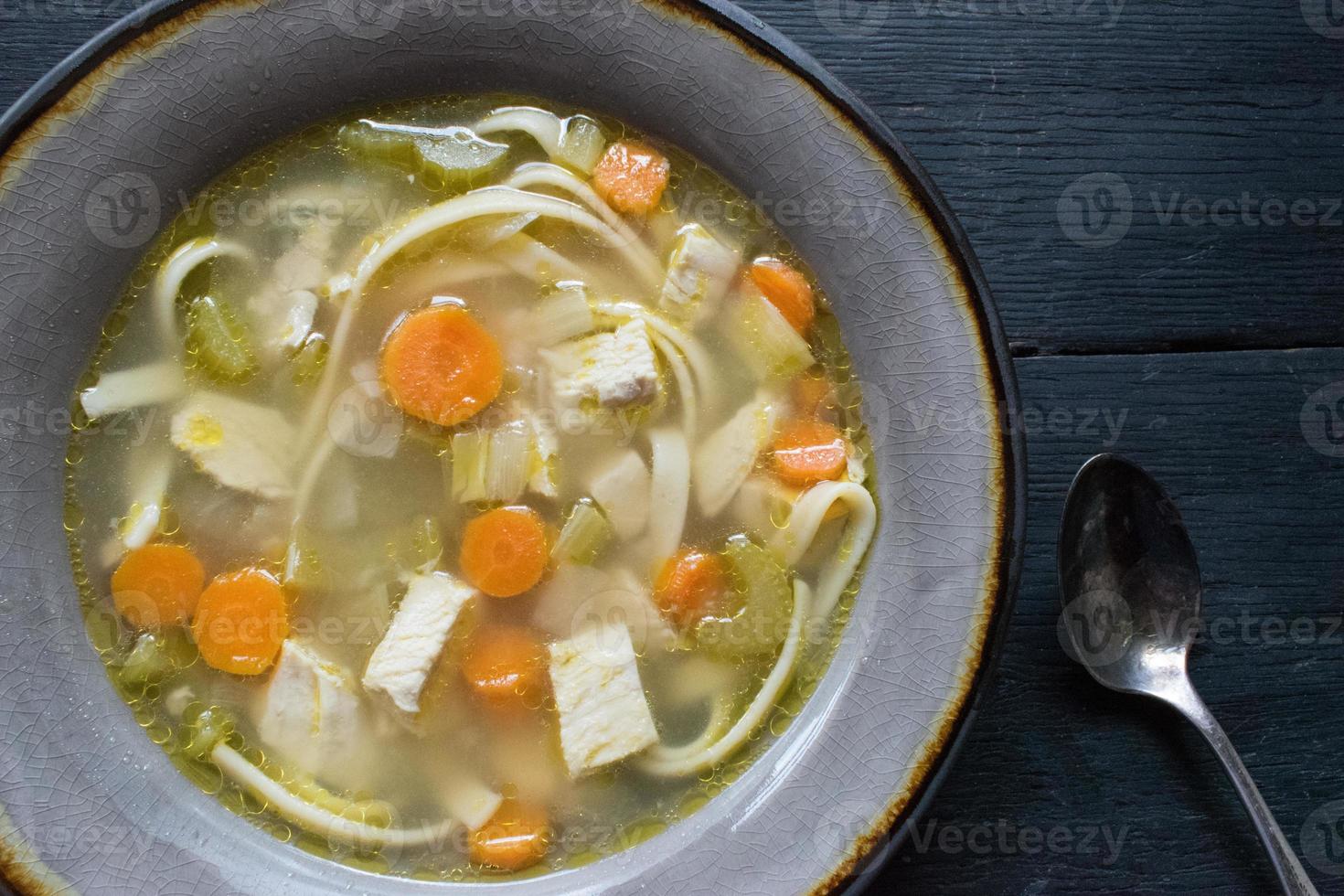 homemade chicken soup with vegetables flat lay photo