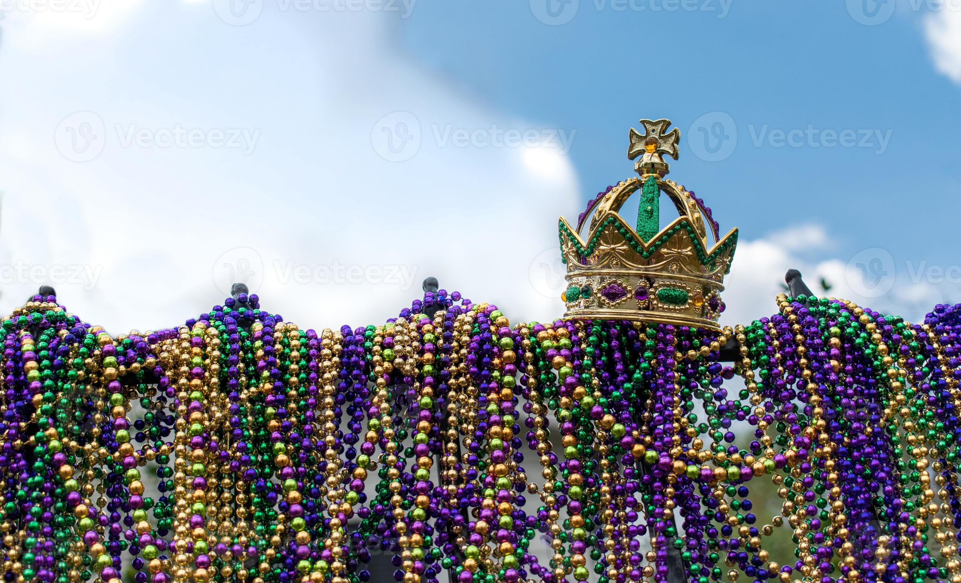 iron fence covered with Mardi Gras beads topped with golden crown