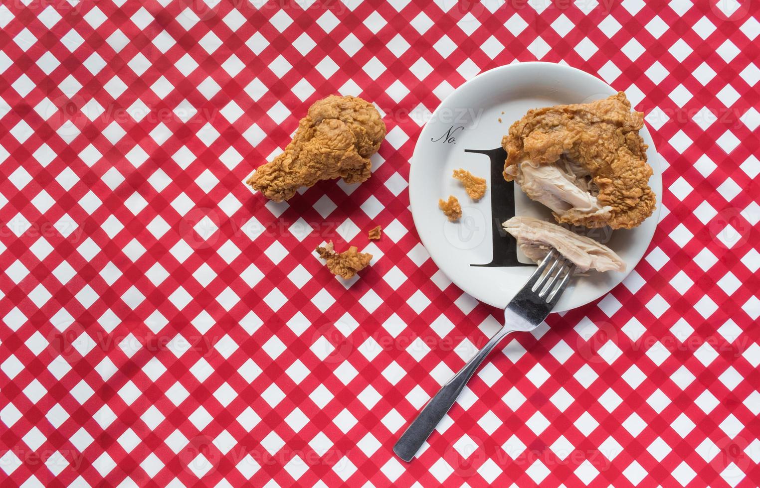 Fried chicken basket on red checkerboard tablecloth flat lay photo