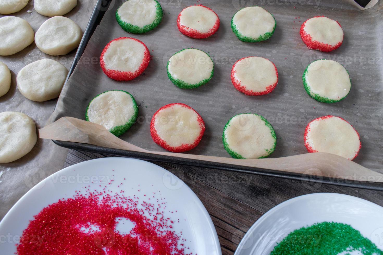 Making Christmas sugar cookies with red and green sprinkles top view photo