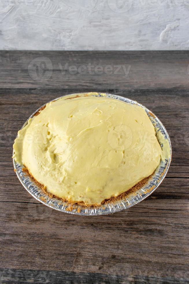 vanilla pudding pie with graham cracker crust in tin pie pan 8724933