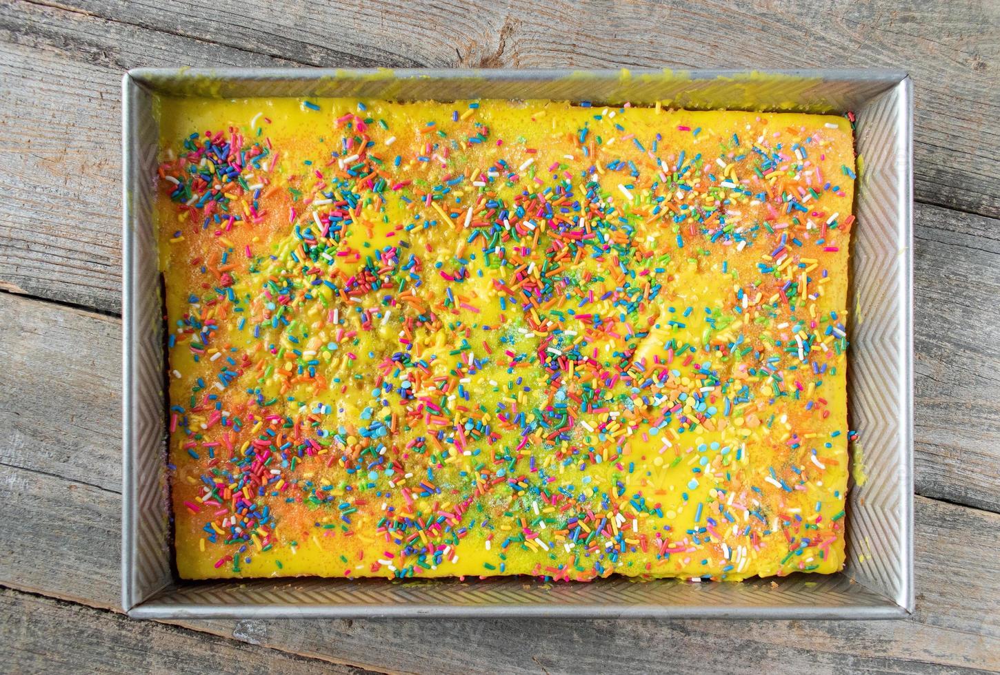 Colorful sprinkle yellow sheet cake in rectangle pan flat lay 8724940