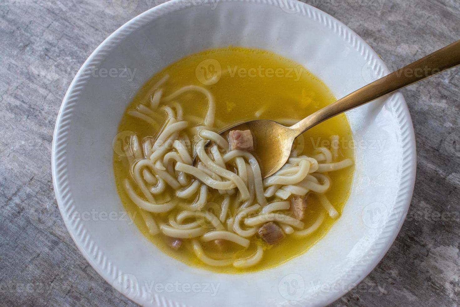 bowl of comfort food of chicken and noodle soup from a can top view photo
