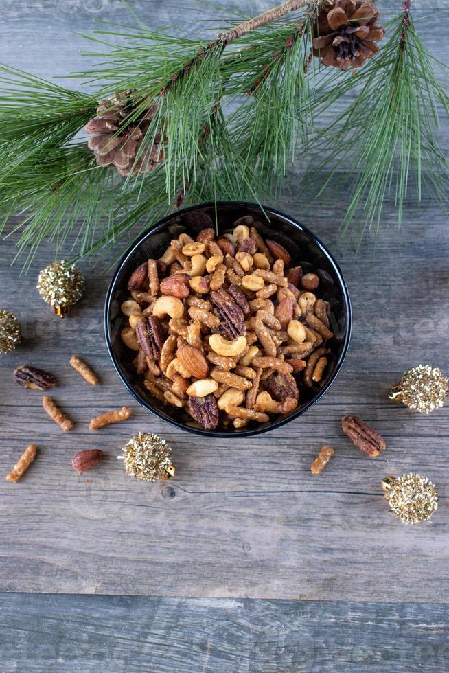 bowl of holiday mixed nuts with Christmas ornaments and tree branch photo
