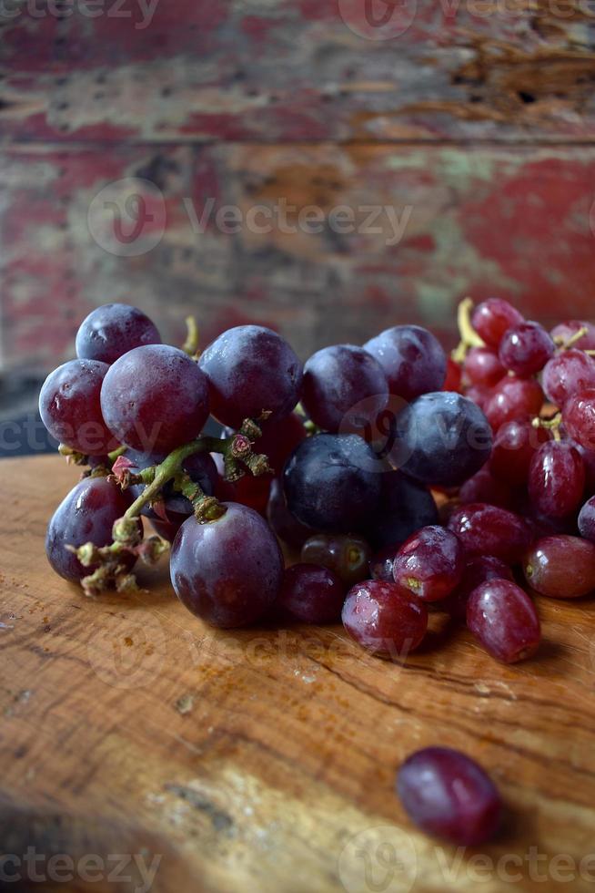 uvas rojas y azules en primer plano de la tabla de cortar foto