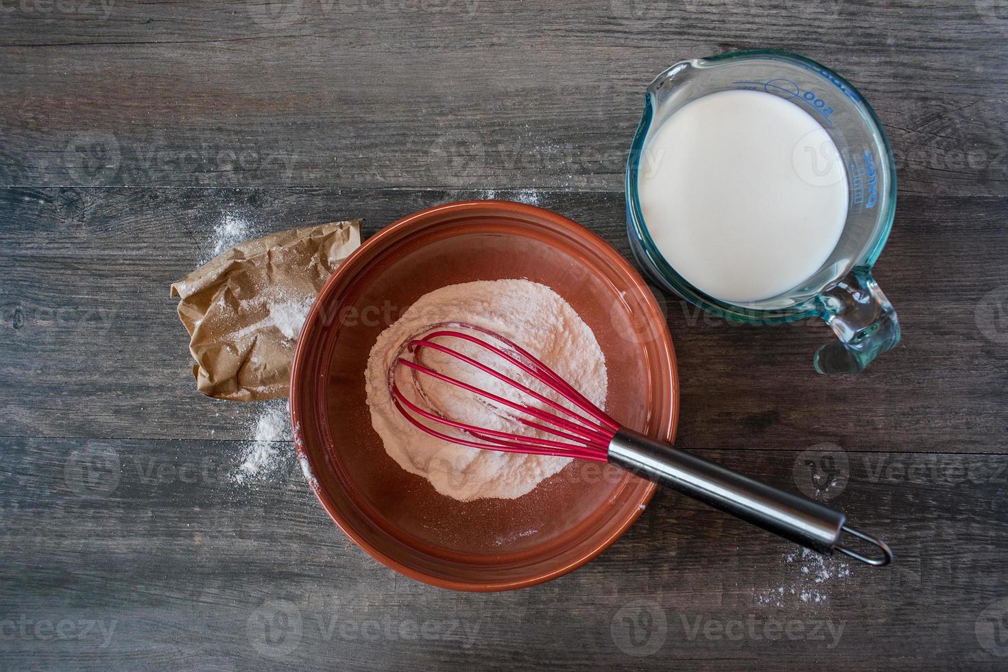 Mixing vanilla pudding with ingredients on rustic table Flat lay photo