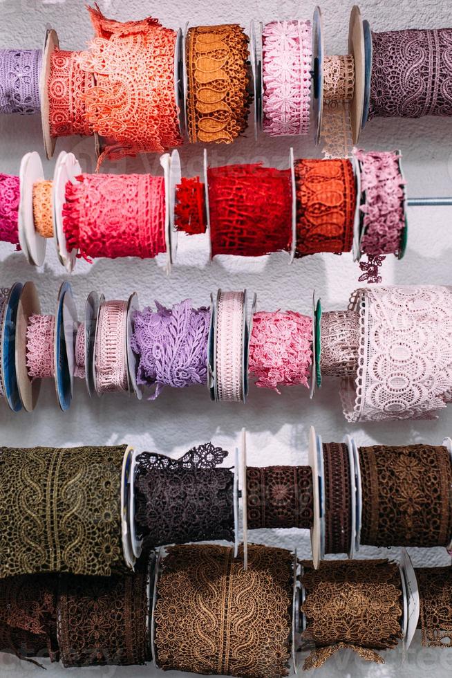 Skeins of lace hang on a shelf in a craft and craft store. photo