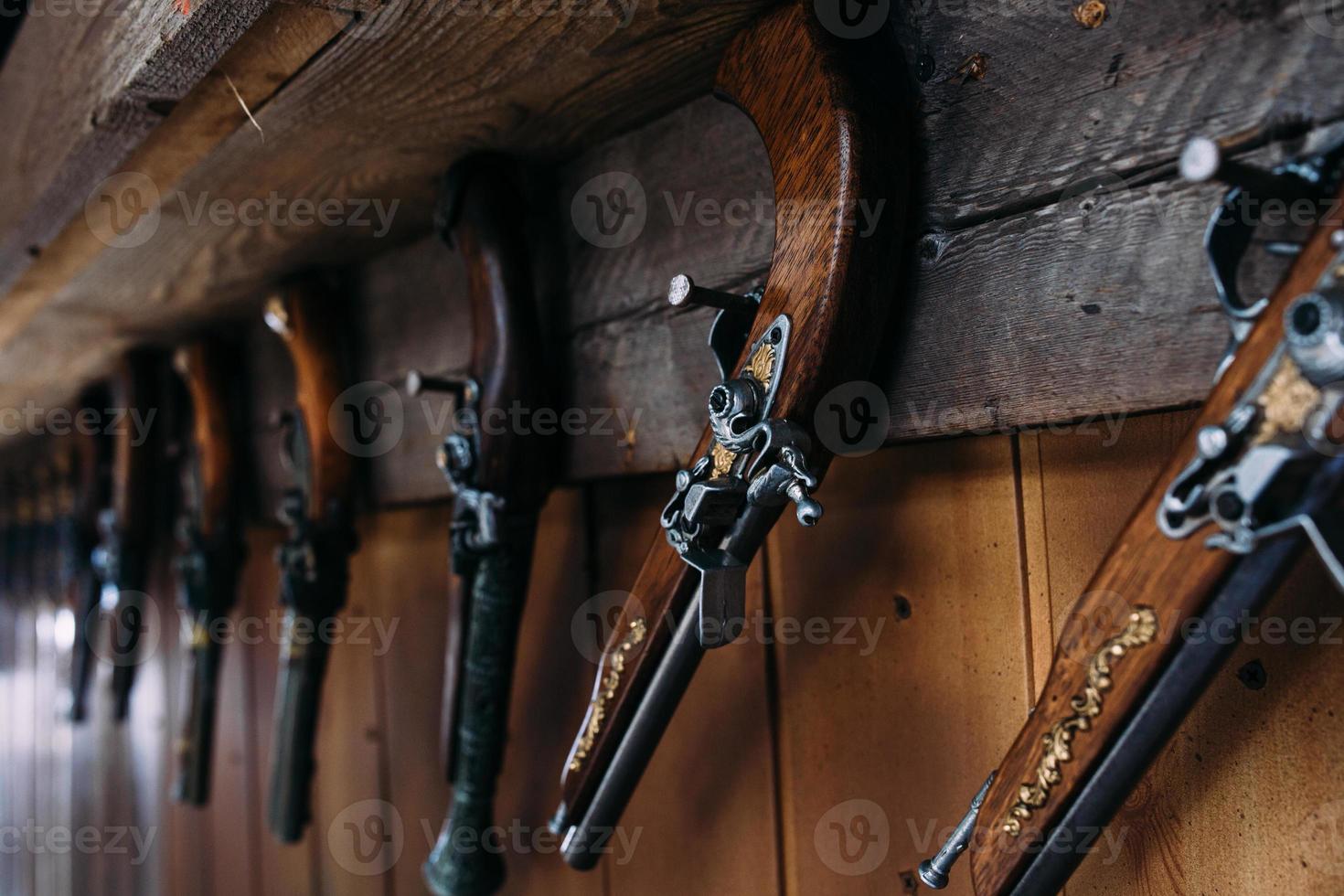 un juego de pistolas viejas en el estante de una tienda de regalos. armas medievales. foto