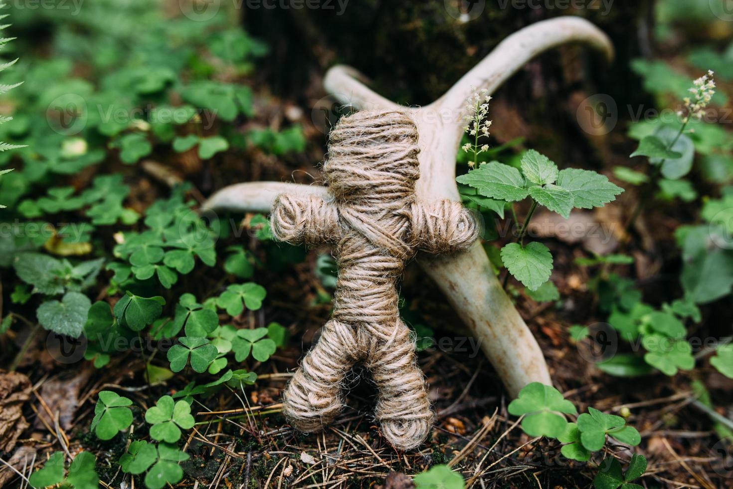 A woven voodoo doll of threads and bones in a ritual in a mysterious forest. photo