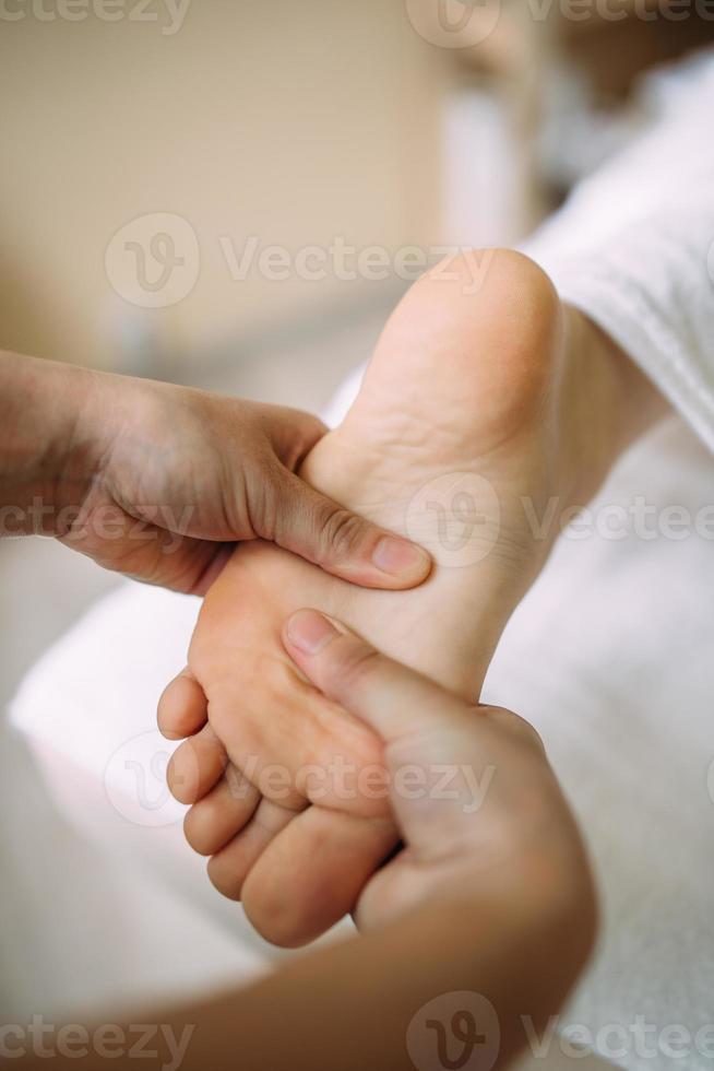 The masseur gives a massage to the female feet at the spa. The concept of cosmetic procedures. photo