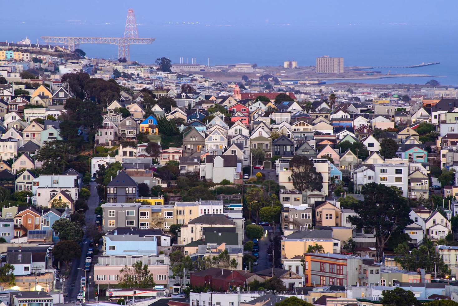 vista de la colina del vecindario de la hora dorada de las casas de san francisco, techos puntiagudos, coloridos y pintorescos con algunas casas victorianas, una vista típica de san francisco. foto