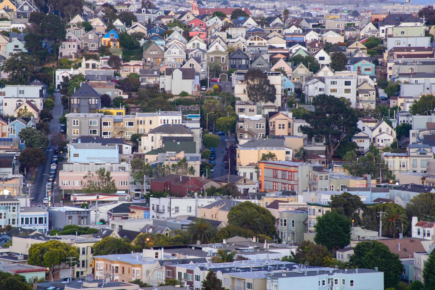 Golden hour neighborhood hill view of San Francisco homes, peaked roofs - colorful and scenic with some Victorian homes - a typical San Francisco view. photo