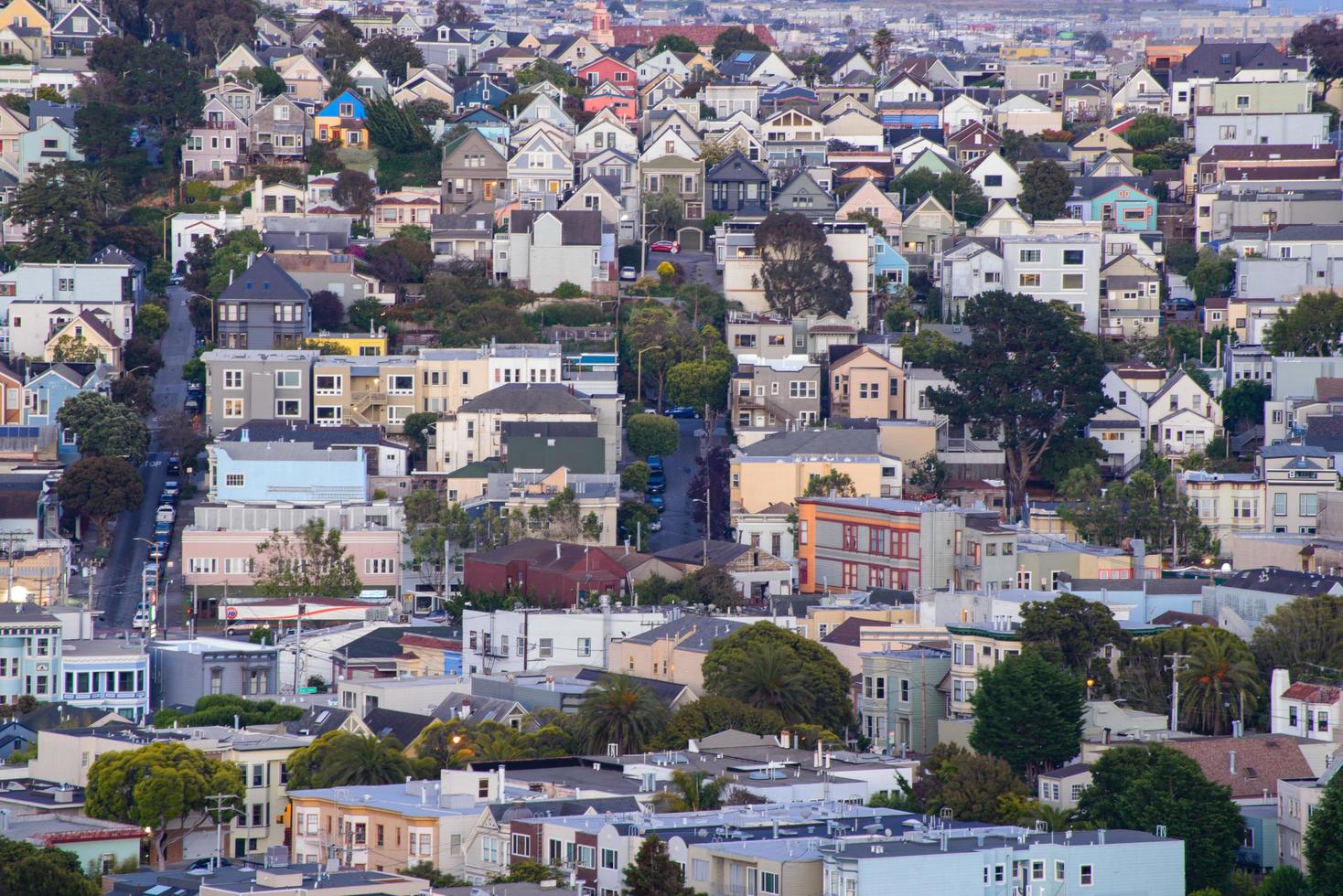 vista de la colina del vecindario de la hora dorada de las casas de san francisco, techos puntiagudos, coloridos y pintorescos con algunas casas victorianas, una vista típica de san francisco. foto