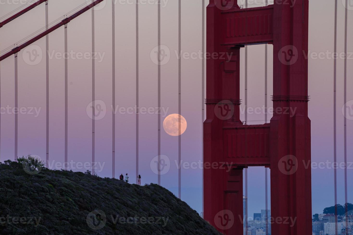 Majestic San Francisco Golden Gate Bridge with June 2022 full moon rising and the north tower as seen from Marin Headlands in California photo