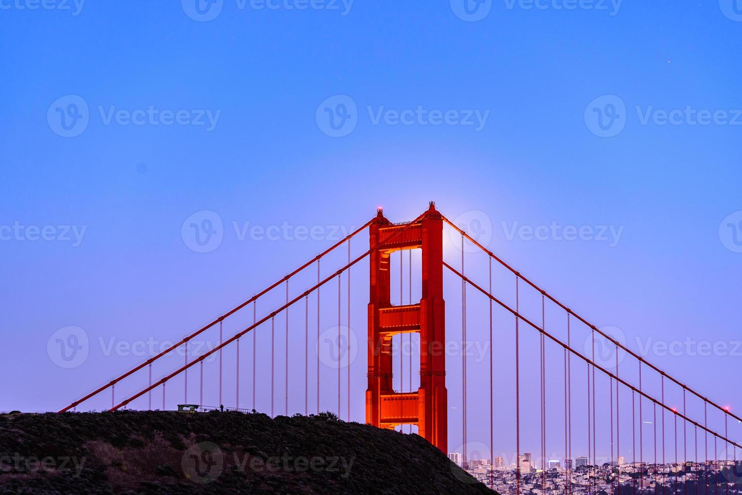 Majestic San Francisco Golden Gate Bridge with June 2022 full moon rising and the north tower as seen from Marin Headlands in California photo