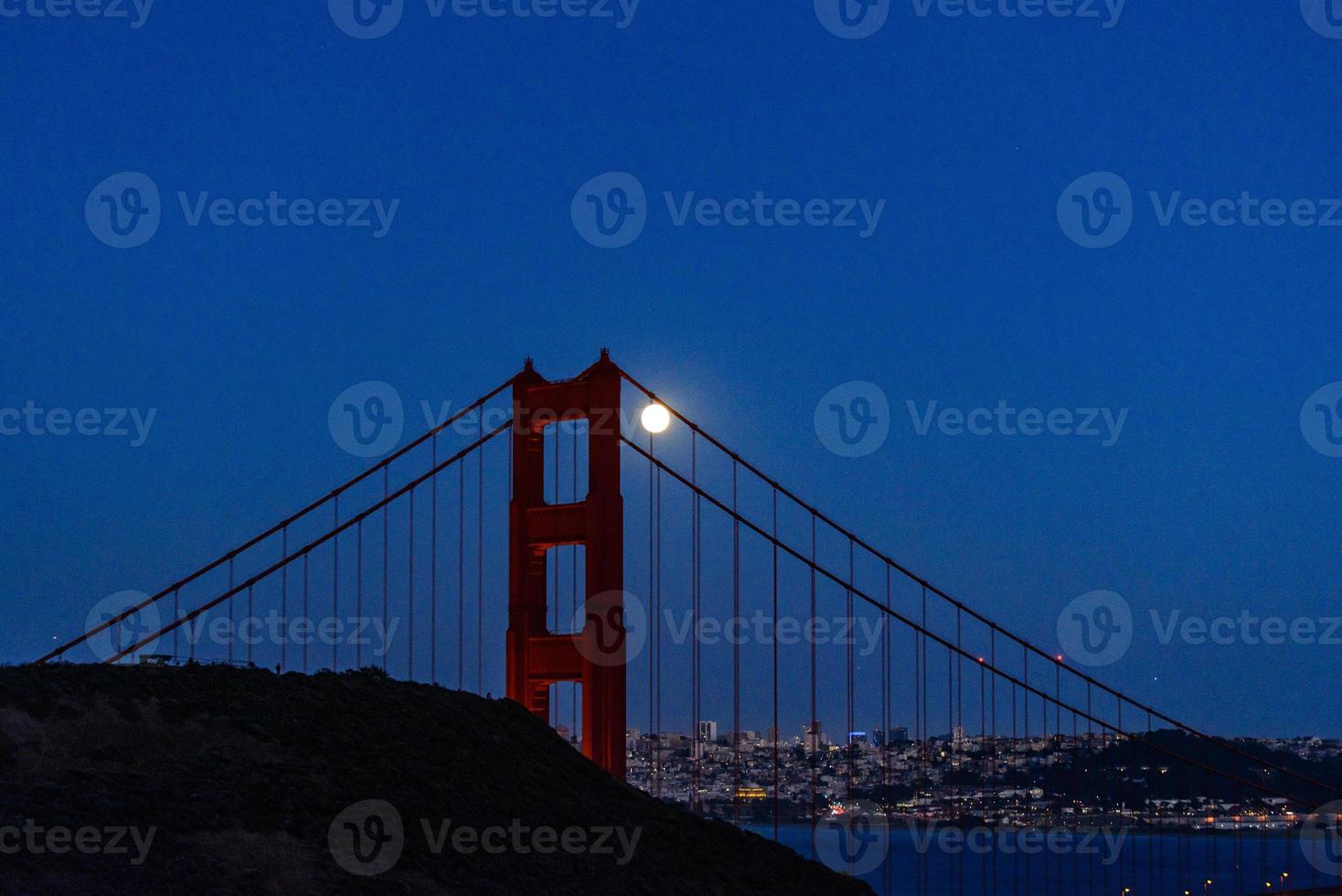 Majestic San Francisco Bay Bridge with June 2022 full moon rising alongside the north tower photo