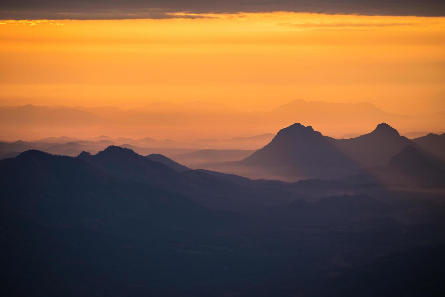 Wonderful landscape sunrise mountain with fog mist yellow gold sky and rising sunshine in the morning on hill photo