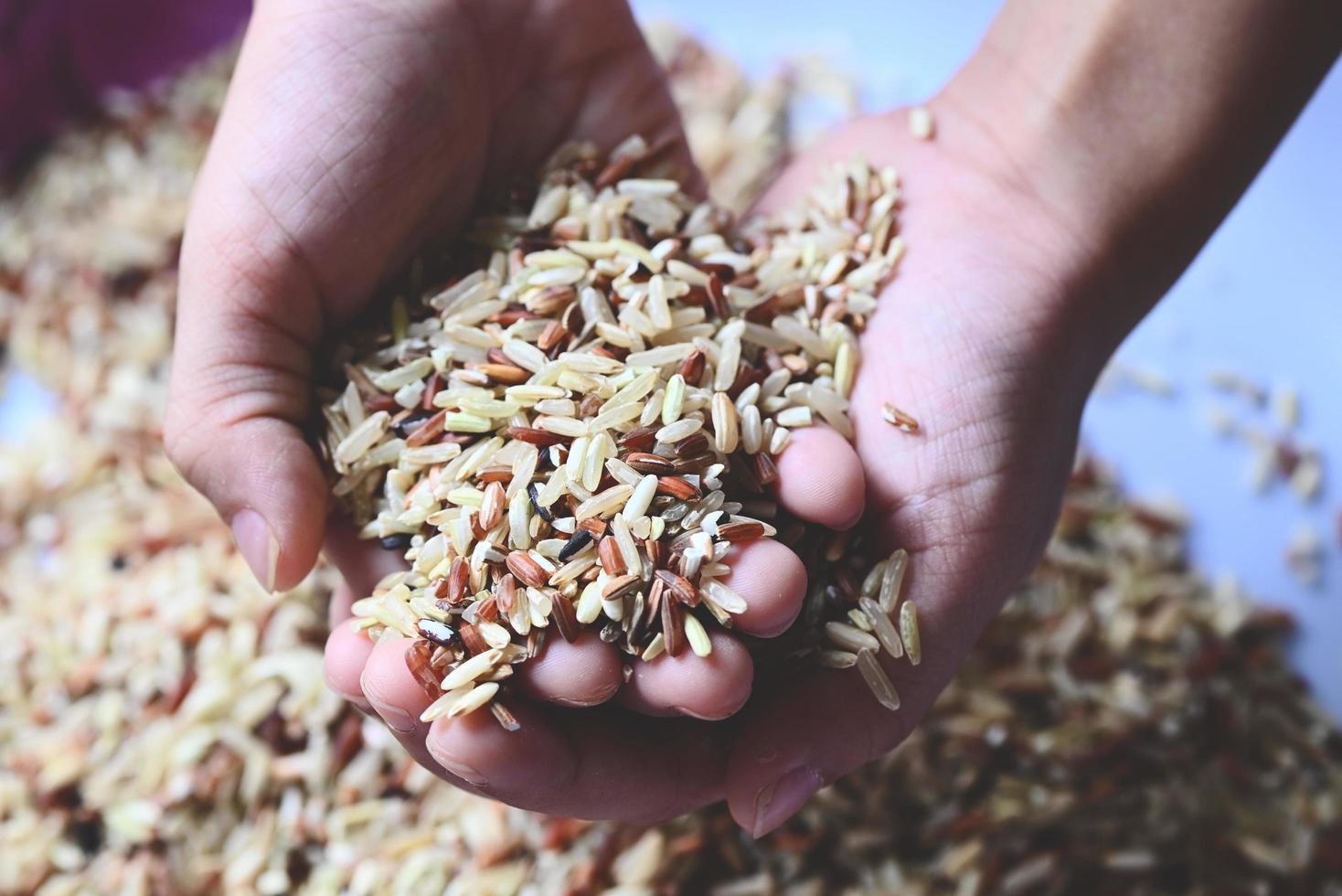 brown rice on child hand is carrying a pile of rice in the hand Islamic fitrah zakat concept , Muslims to help the poor and needy, help donate food concept photo
