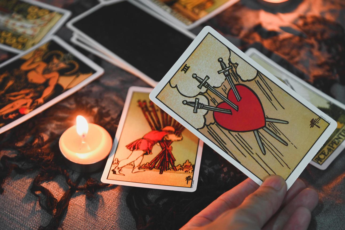 Tarot reading with tarot card background and candlelight on the table for Astrology Occult Magic Spiritual Horoscopes and Palm reading fortune teller tarot reader photo