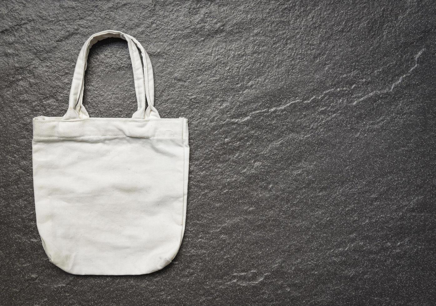 White tote canvas fabric eco bag cloth shopping sack on dark background photo