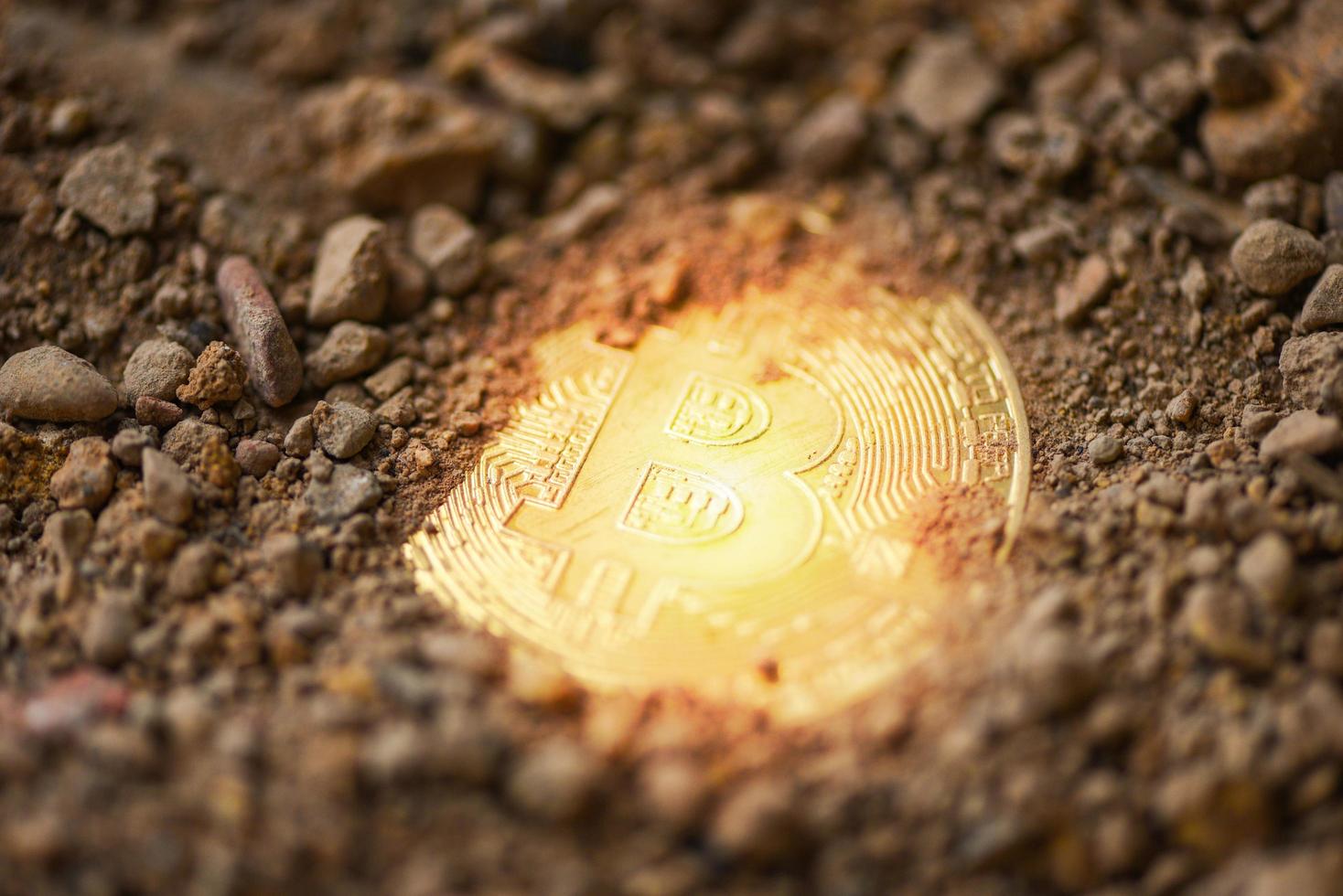 Bitcoin Golden on ground soil deep with light Virtual cryptocurrency bitcoin mining concept photo