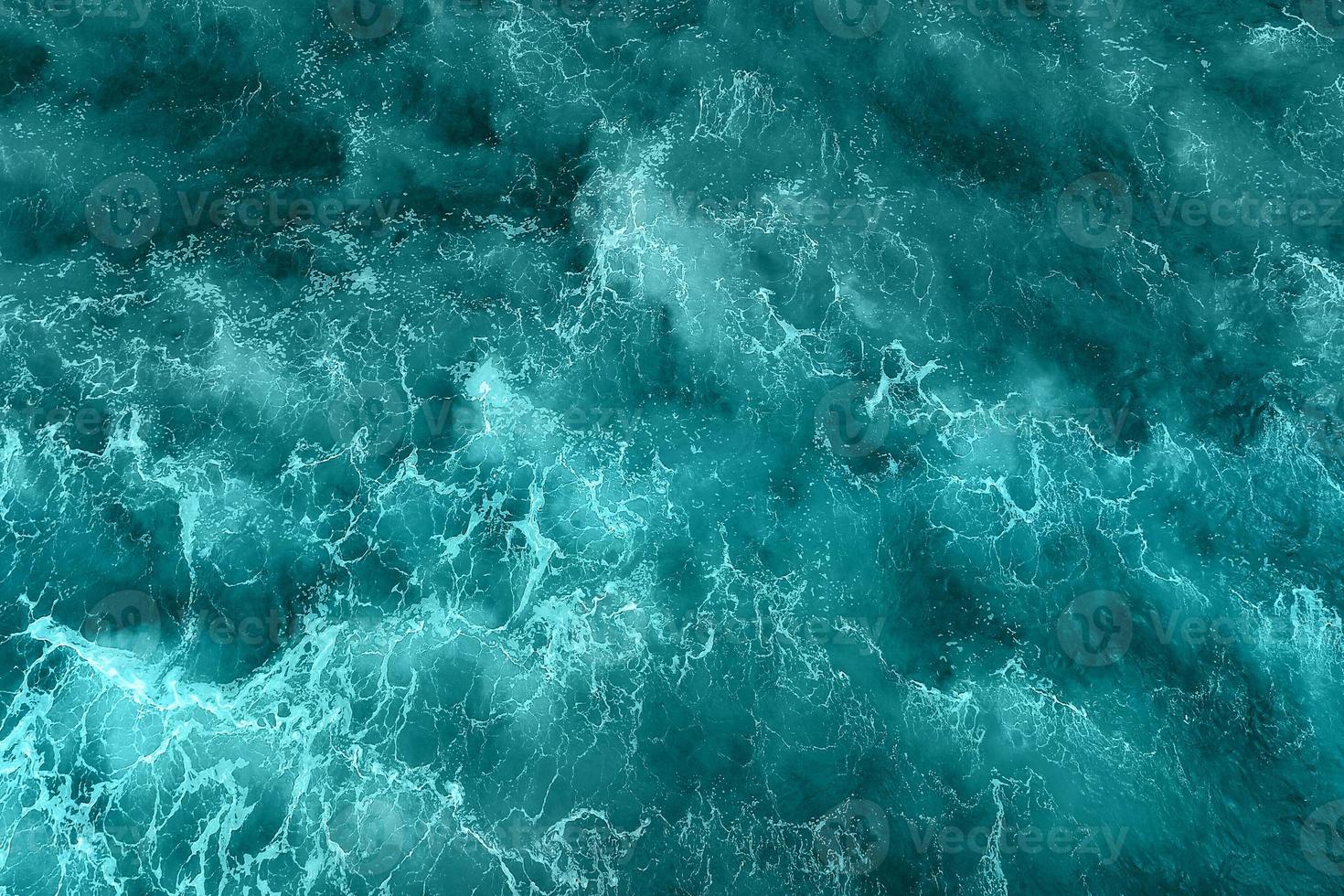 Defocus blurred blue water splash in the sea rippled water detail background. Water splash, water spray background. photo