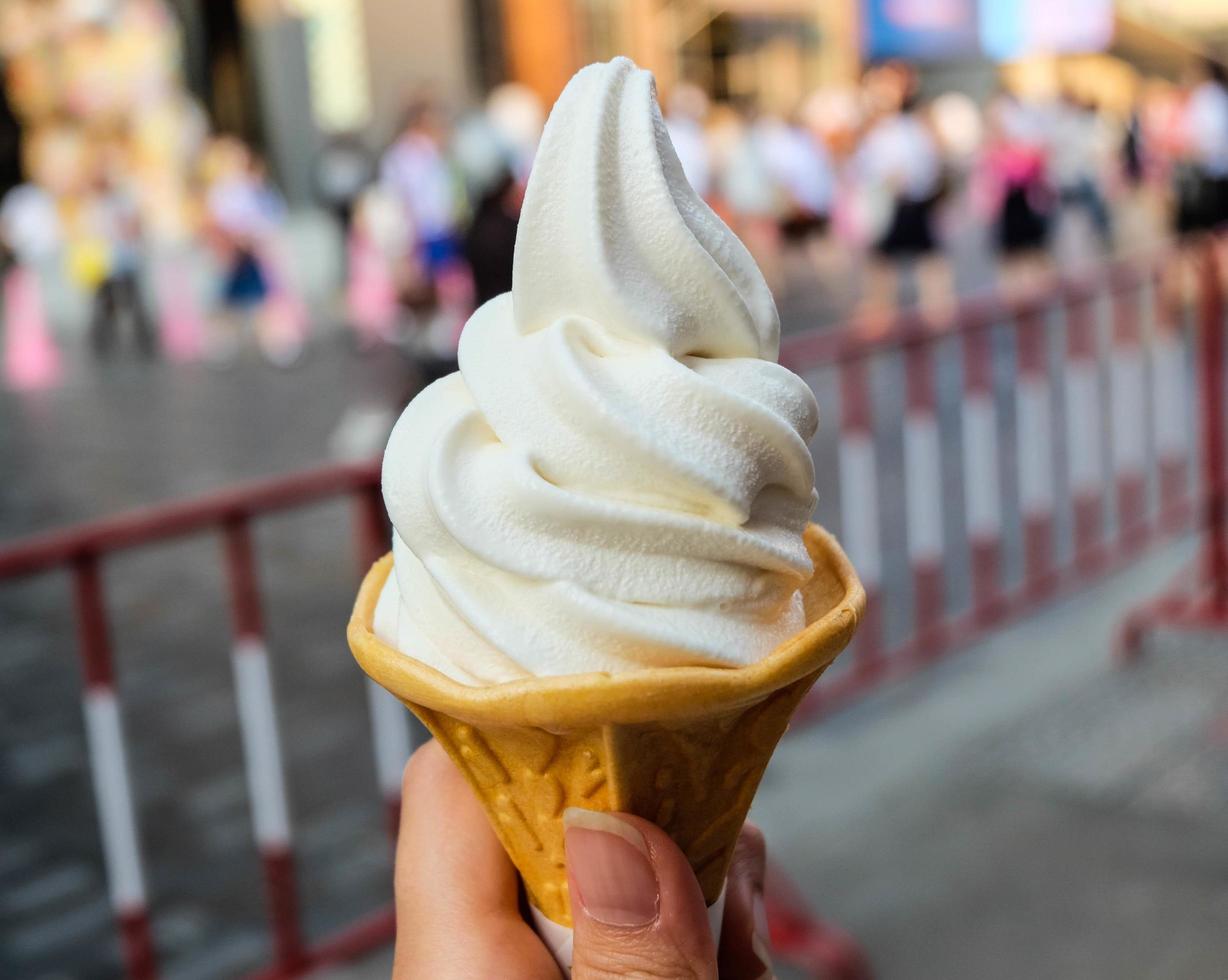 Ice cream cone held up in the city photo