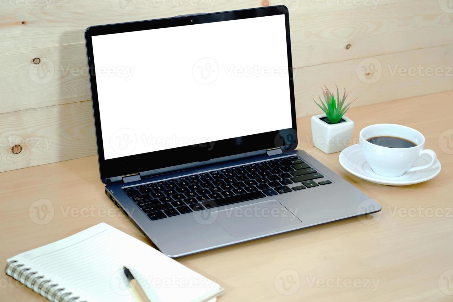taza de café y computadora portátil en la mesa de la oficina foto