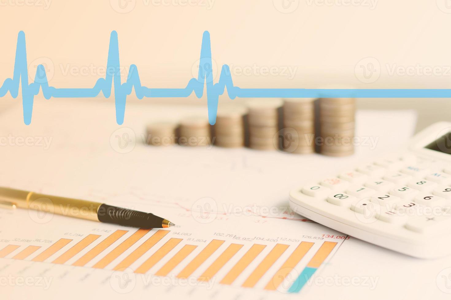 gráfico con calculadora, bolígrafo y monedas foto