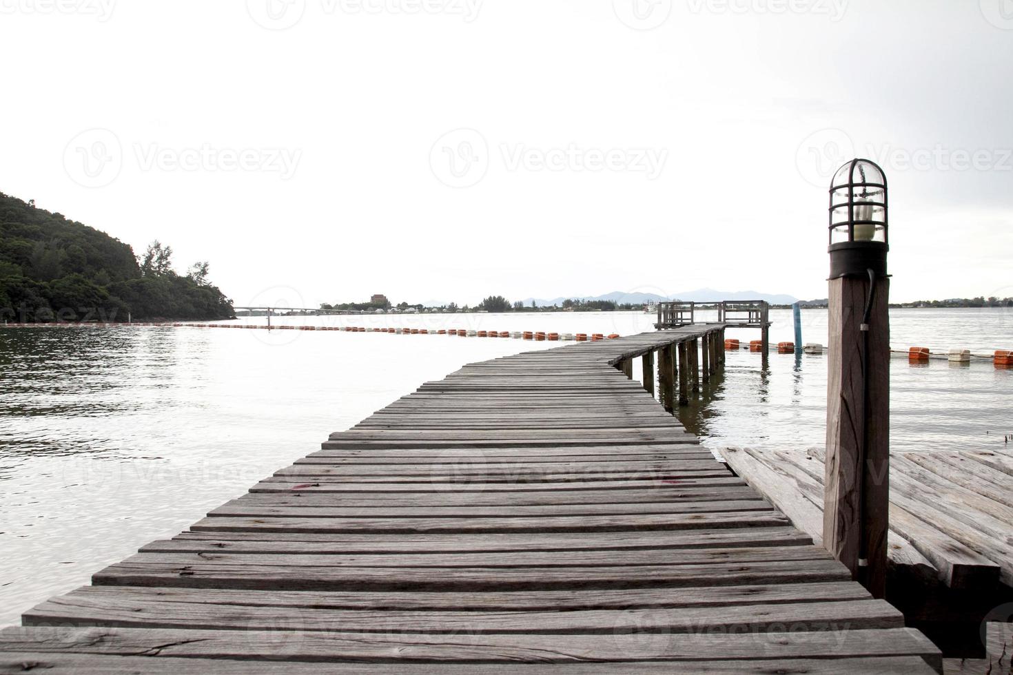 View of a wooden pier on the seashore with clear morning sky and sea photo