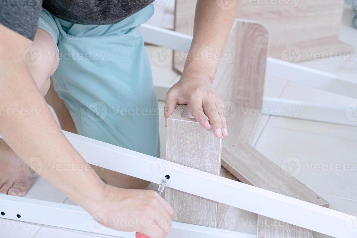 Young Asian Man Assembling shelves photo